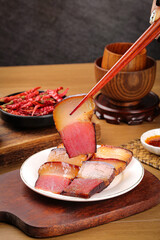 Wood-smoked bacon slices served with chopsticks on wooden table with traditional Asian dining elements