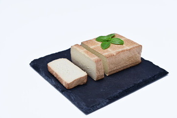 sliced ​​tofu on a black board on white background close-up