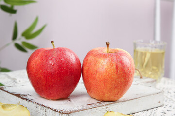Fresh Red Gala Fuji Apples from Xinjiang Aksu Region on Rustic Wooden Board with Apple Juice Glass