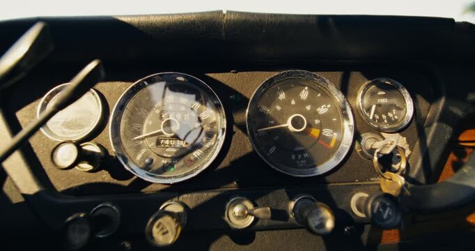 Close-up of a man's hand as he inserts the key into the ignition and starts the retro car