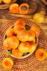 Fresh Organic Apricots in Wicker Basket on Rustic Wooden Background