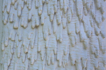 Mur avec décoration de stalactites en ciment peinte en blanc