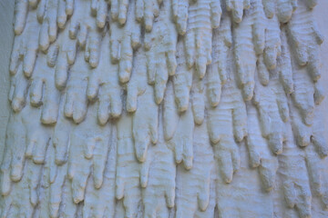 Mur avec décoration de stalactites en ciment peinte en blanc