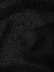 Dark dense fabric for sewing clothes, ironed, the texture of the fabric is visible