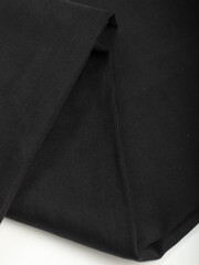 Dark dense fabric for sewing clothes, ironed, the texture of the fabric is visible