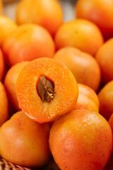 Fresh Xinjiang Apricots with Cut Half Showing Pit - Natural Orange Fruit with Water Droplets