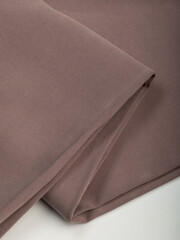 Light, dense fabric for sewing clothes, ironed, the texture of the fabric is visible
