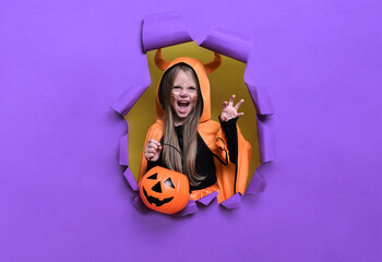  Little girl in a witch costume with a bucket of pumpkins for Halloween