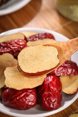 Xinjiang Red Jujube Dates Dried Chinese Superfruit Slices on Wooden Spoon Traditional Healthy Snack