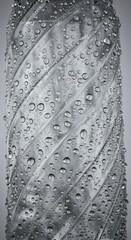 Monochrome image of a textured bottle with glistening water droplets is perfect for product design concepts and abstract backgrounds.
