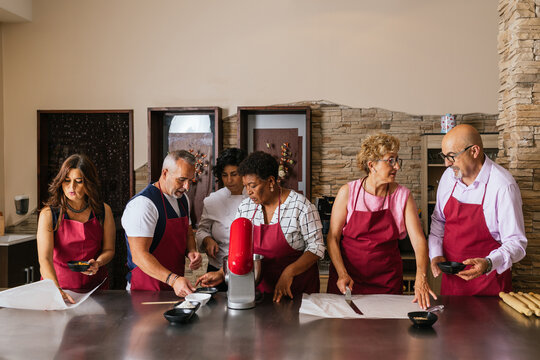 Chefs preparing food in restaurant kitchen during cooking course