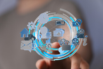 Person interacts with a digital interface showing various technology icons. Network, connection, digital.