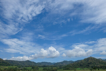 Panorama of hills during the day with blue sky and soft white clouds. Concept of climate and weather, ecology and environment. For graphic design and banners