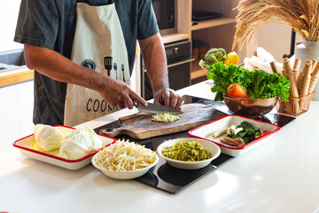 Man Preparing Fresh Vegetables in Kitchen with Healthy Ingredients