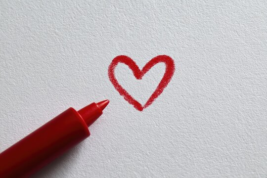 Red heart drawing on white paper with a red marker