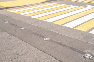 Yellow and white pedestrian crosswalk with tactile paving