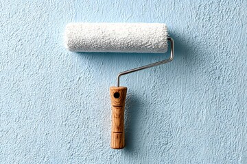 Obraz premium White roller on textured blue wall paint roller white paint