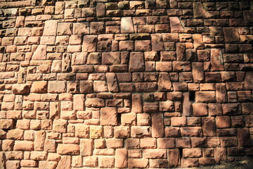 Old sandstone masonry wall in sunlight