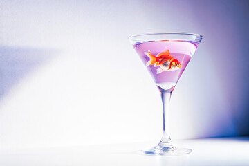 Holiday cocktail with goldfish in pastel icy lavender glass  
