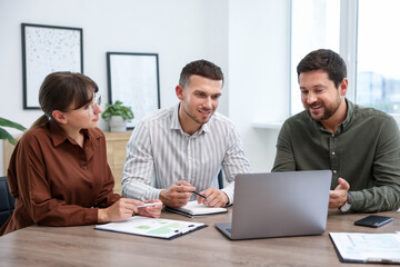 Couple having meeting with business consultant at table in office