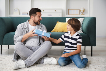 Happy Father's Day. Son giving his dad gift at home