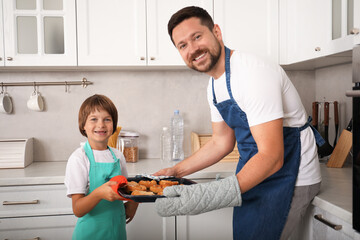 Father and son baking pastries in kitchen