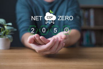 Hand present a glow net zero 2050 CO2 emission goal symbol with eco icons,representing sustainable development,culture change,industrial transformation,climate action,and environmental responsibility.