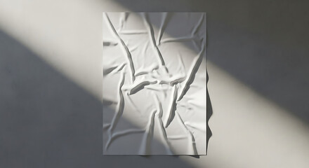 Crumpled White Poster on Textured Wall with Sunlight and Shadows