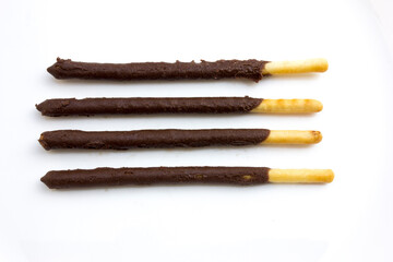 Some chocolate stick biscuits on a white background.