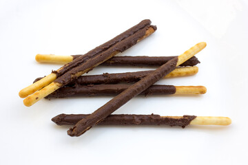 Some chocolate stick biscuits on a white background.