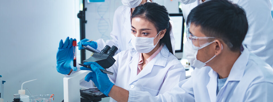 Group of scientists collaborating in a laboratory, engaging in teamwork and planning around experiments, symbolizing cooperation, diversity, and innovation in healthcare and science.