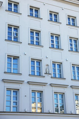 Reflective windows in ornate white building facade, serene 
