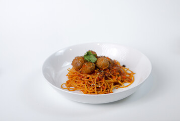 Spaghetti meatballs on a white plate with a white background