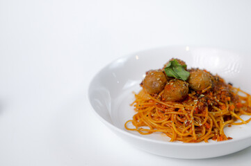 Spaghetti meatballs on a white plate with a white background