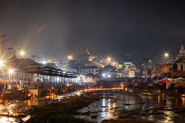 Fototapeta premium Illuminated Pashupatinath Temple Nightscape with Bagmati River Reflections