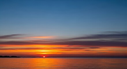 Naklejka premium Serene Sunset Over Calm Water with Vivid Colors and Tranquil Sky at Dusk