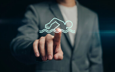 Businessman's hand touching a glowing virtual swimming icon, symbolizing health, fitness, and aquatic sports activities or wellness programs.