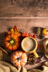 Pumpkin pie spices latte drink, cosy autumn coffee drink, orange pumpkin, cinnamon, wooden rustic background
