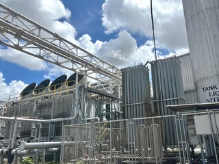 A large-scale industrial facility featuring massive cooling towers and cryogenic storage tanks...
