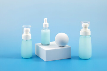Skincare Product Collection on Blue Display. Skincare bottles arranged on geometric platforms with a blue background.