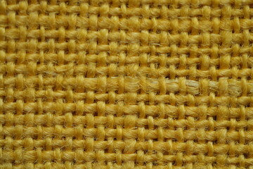 Yellow burlap fabric texture – close-up background top view 