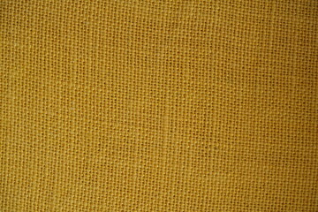 Yellow burlap fabric texture – close-up background top view 