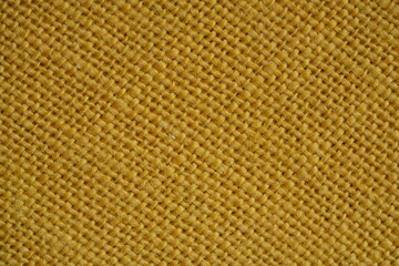 Yellow burlap fabric texture – close-up background top view 
