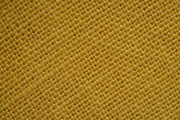 Yellow burlap fabric texture – close-up background top view 