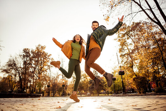 Happy couple enjoying a fun autumn day outdoors in a park surrounded by colorful foliage during a city walk - Powered by Adobe