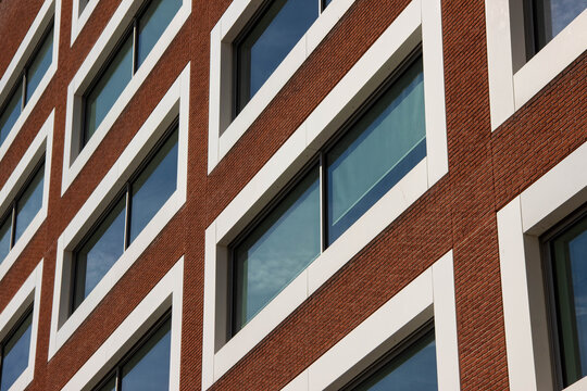 Modern architectural building facade featuring a striking pattern of windows and brickwork, showcasing contemporary design elements and urban aesthetics in a vibrant city environment