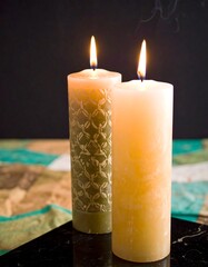 Two lit candles on a dark surface