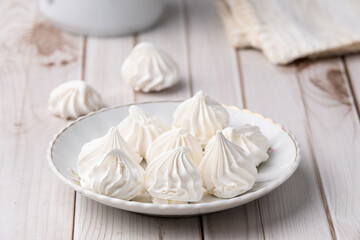 Fresh homemade meringue cookies over wooden table
