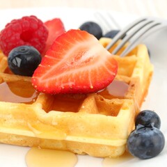 Waffles topped with berries and syrup