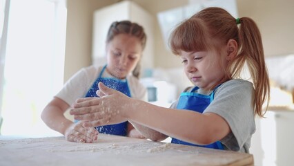 kids are baking. children knead dough and flour in the kitchen. happy family kid concept. baby children bake pizza dough. sisters baking dream cookies. teamwork children knead dough and flour
